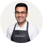 Total Branded employee Dhruv wearing the Nima 320 g/m2 Aware™ Denim Apron